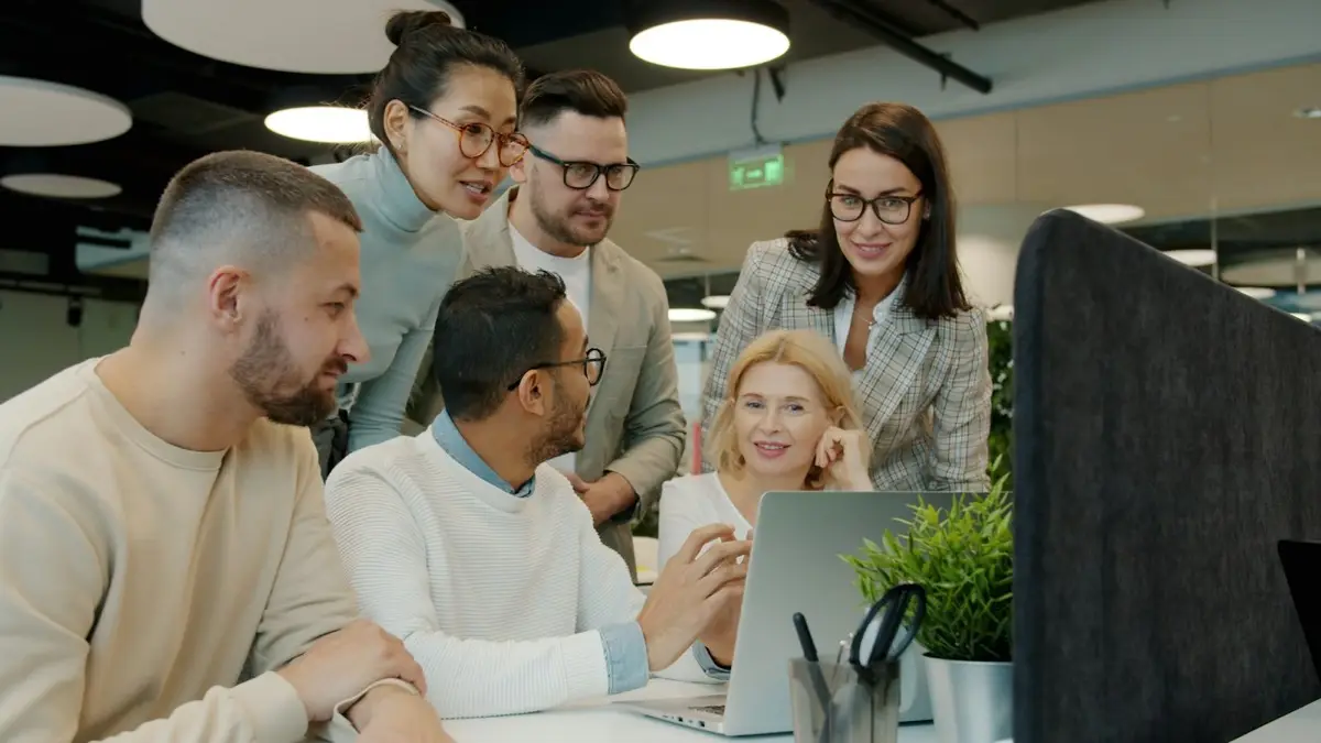 A team looking at a laptop together
