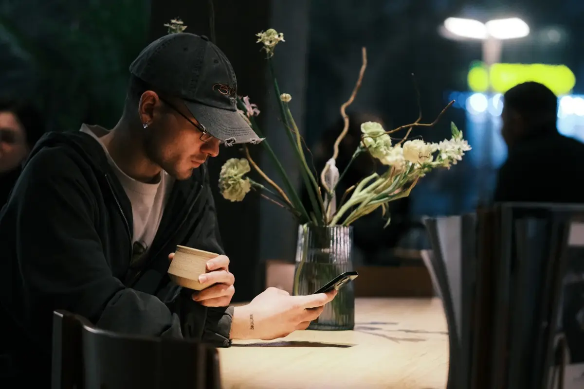 A customer checking their phone at a cafe table
